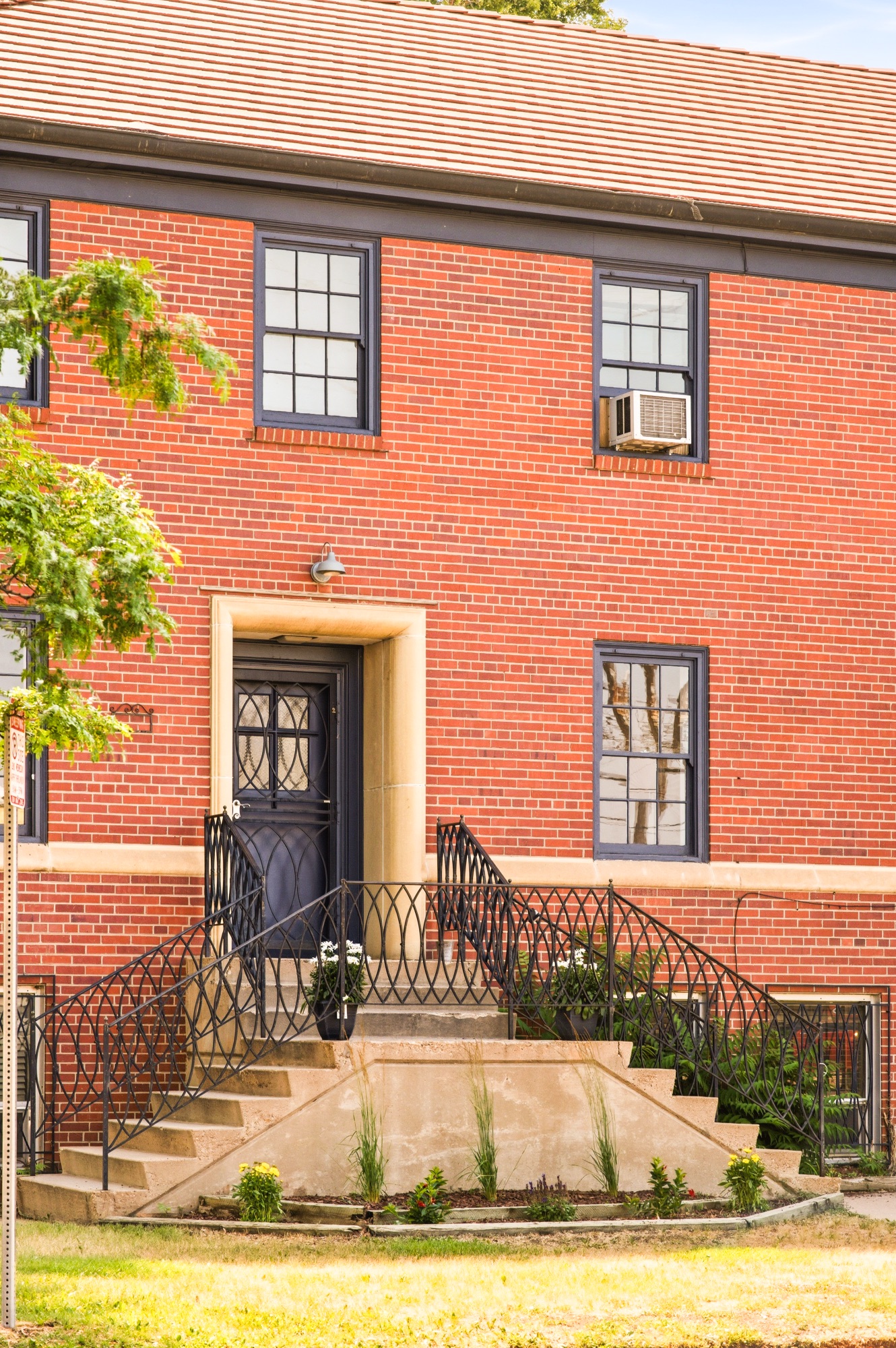 Unit 2A private entrance — red brick facade with wrought-iron double staircase, The Nunnery, 375 S Navajo St, Denver
